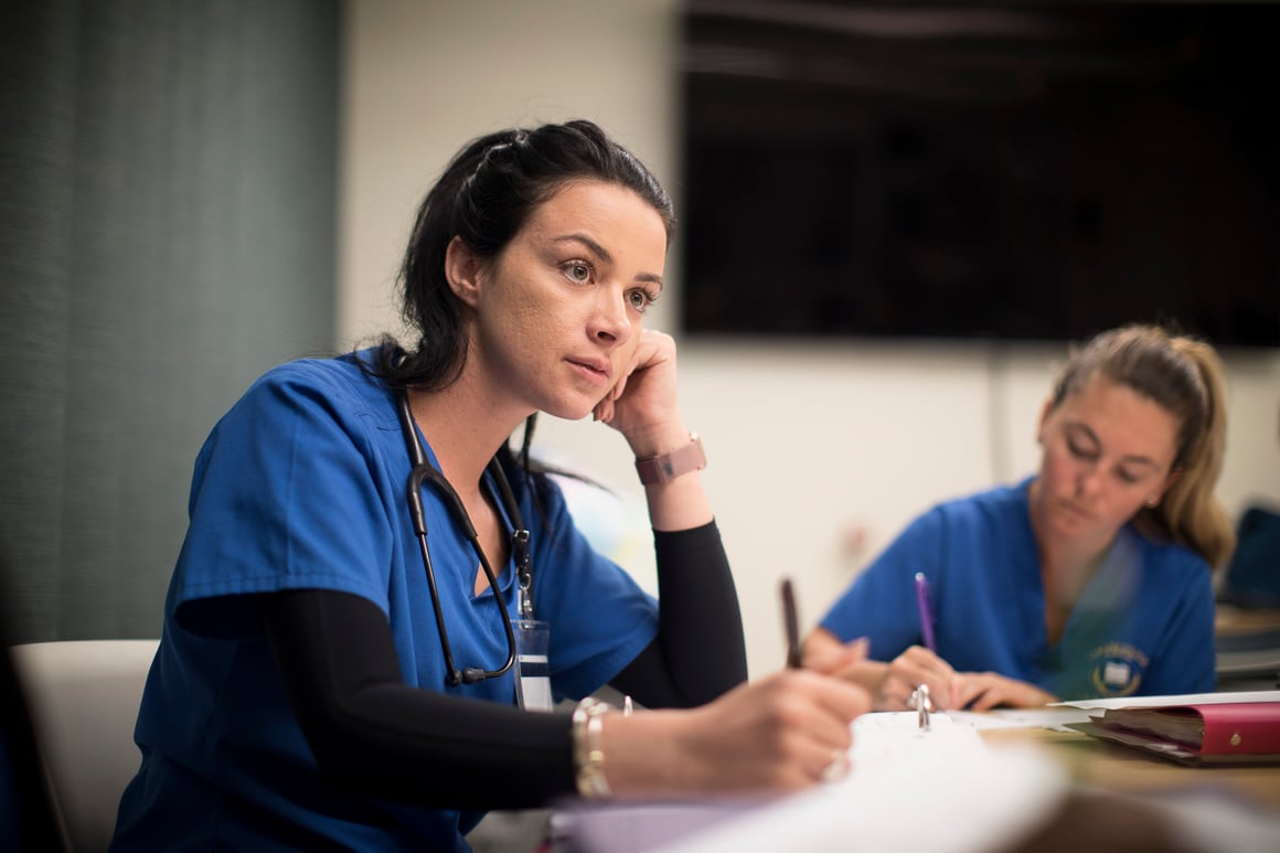 Student in scrubs listening