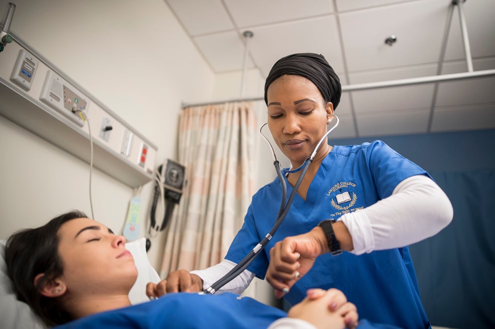 Student nurse with stethoscope taking vitals