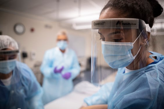 Student in face shield in SIM lab with instructor in background