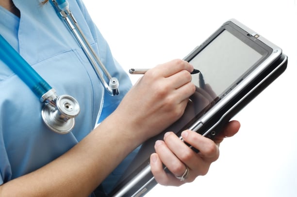 Nurse writing in ipad