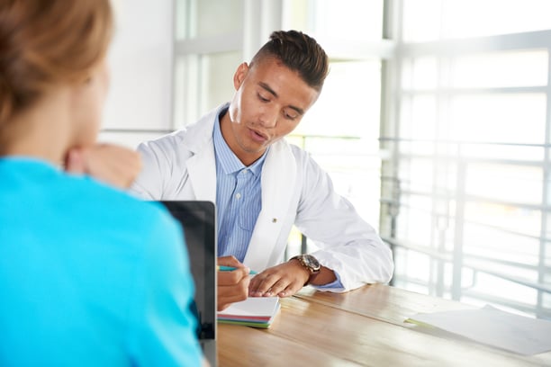 Team of doctor and nurse discussing a patient diagnosis sitting at the desk in bright modern office-3